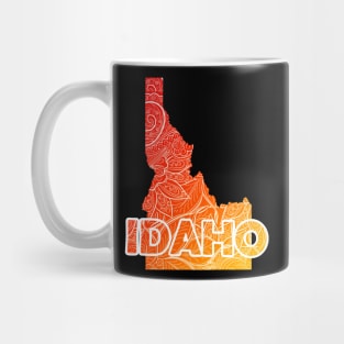 Colorful mandala art map of Idaho with text in red and orange Mug